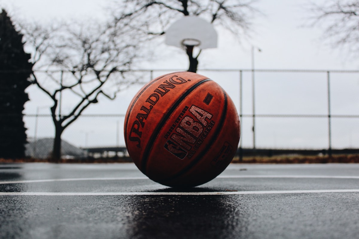 Basketball resting on a wet outdoor court